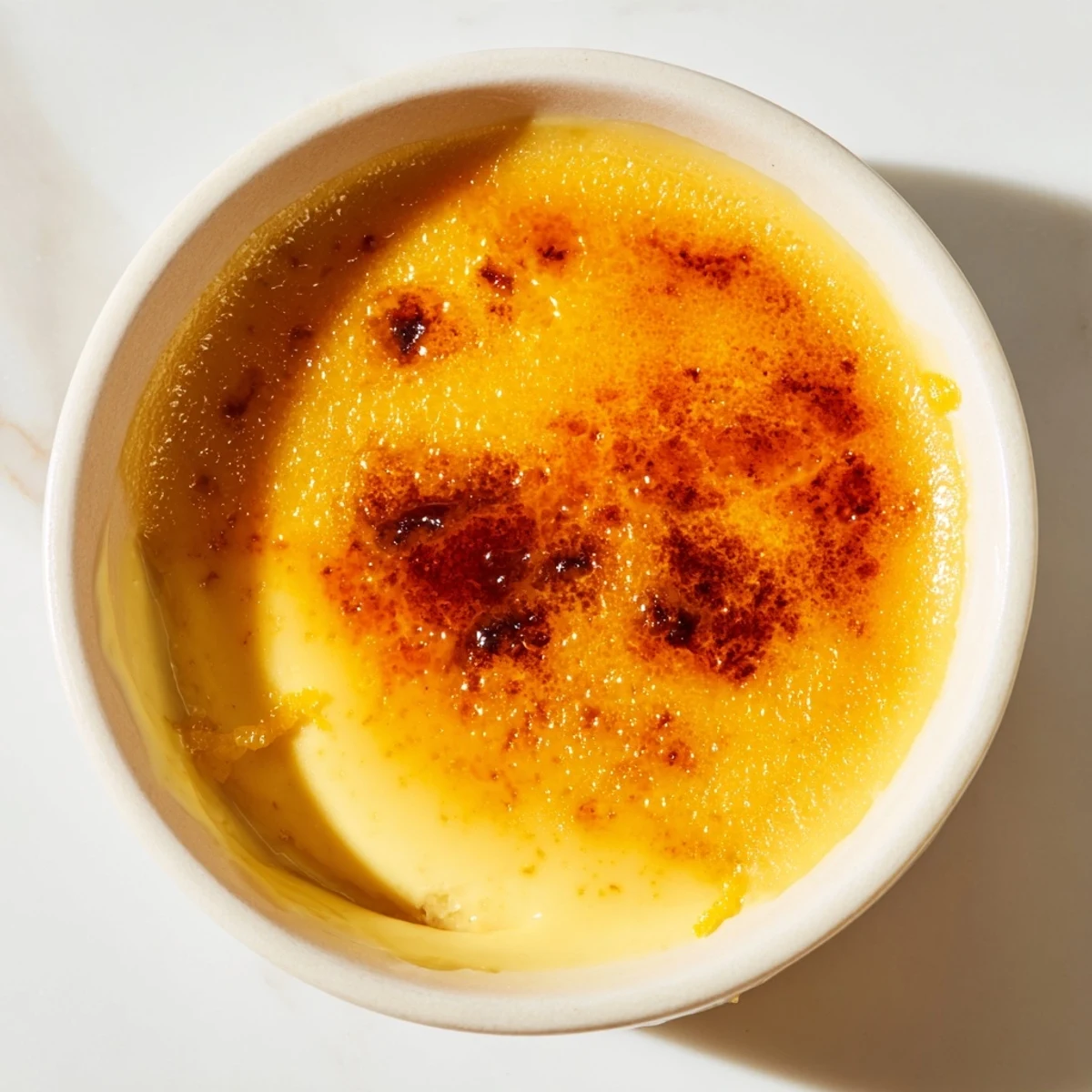 Crema Catalana cremosa con caramelo dorado, un postre español ideal para ocasiones especiales.  
