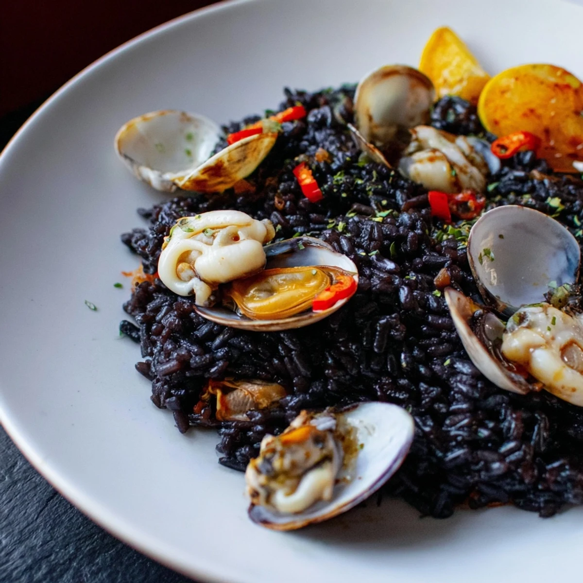 This modern Paella Negra presents a delicious, dark rice dish with tender seafood and herbs.