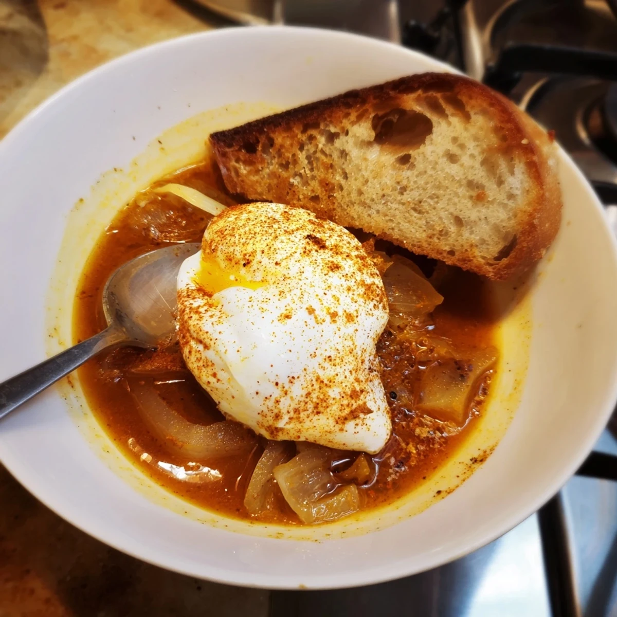 A steaming bowl of The Easiest 5-Ingredient Sopa de Ajo, topped with a perfectly poached egg.