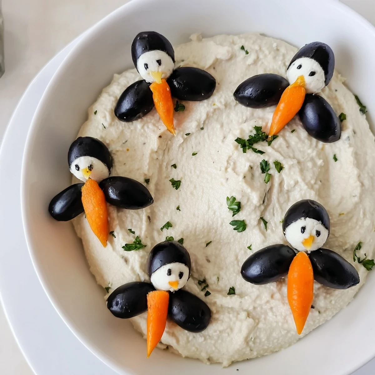 Creamy Winter Dip, featuring smooth white bean dip decorated with adorable olive penguins.