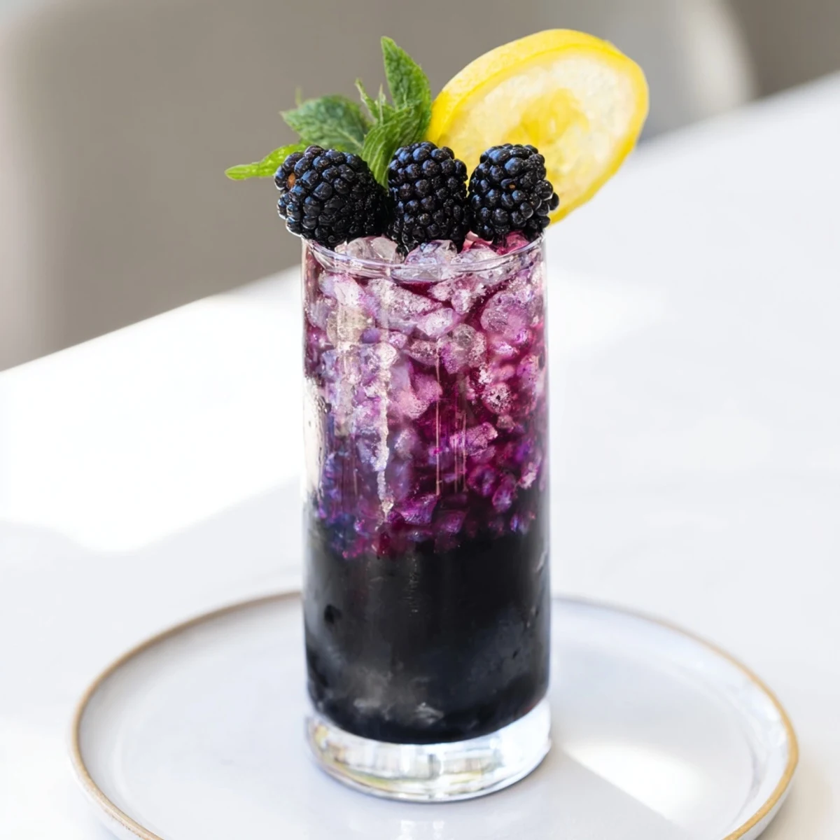 This photo presents a layered Dark Matter Mocktail, a vegan-friendly, dark and mysterious drink, perfect for parties.