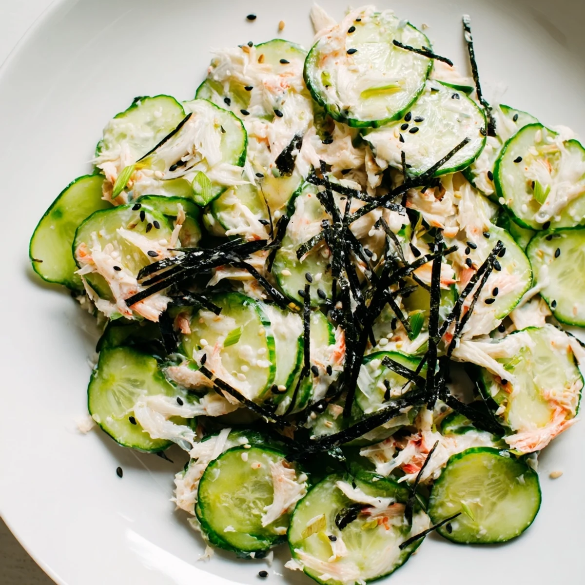 Bright California Roll Cucumber Salad, ready to serve, with sesame seeds and nori strips vividly displayed.