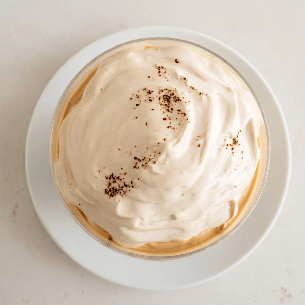 Whipped Dalgona Coffee, a fluffy, cloud-like topping sits beautifully on a cold glass of milk.