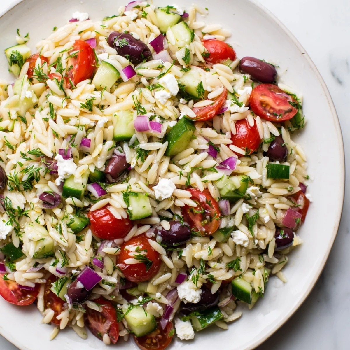 Close-up of a refreshing Greek Orzo Salad, perfect for a summer picnic or easy lunch.