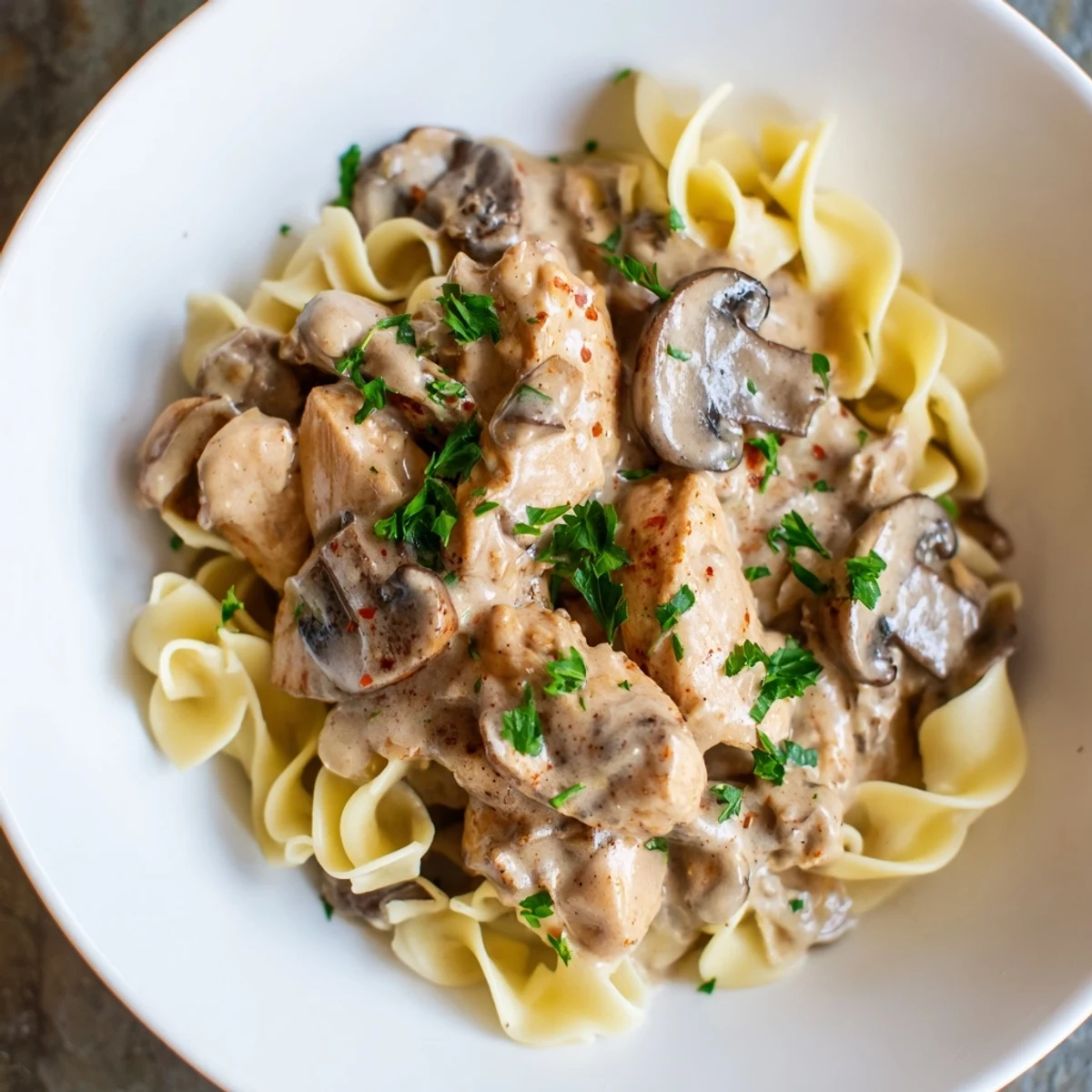 Creamy Chicken and Mushroom Stroganoff served over buttery egg noodles, a comforting classic.