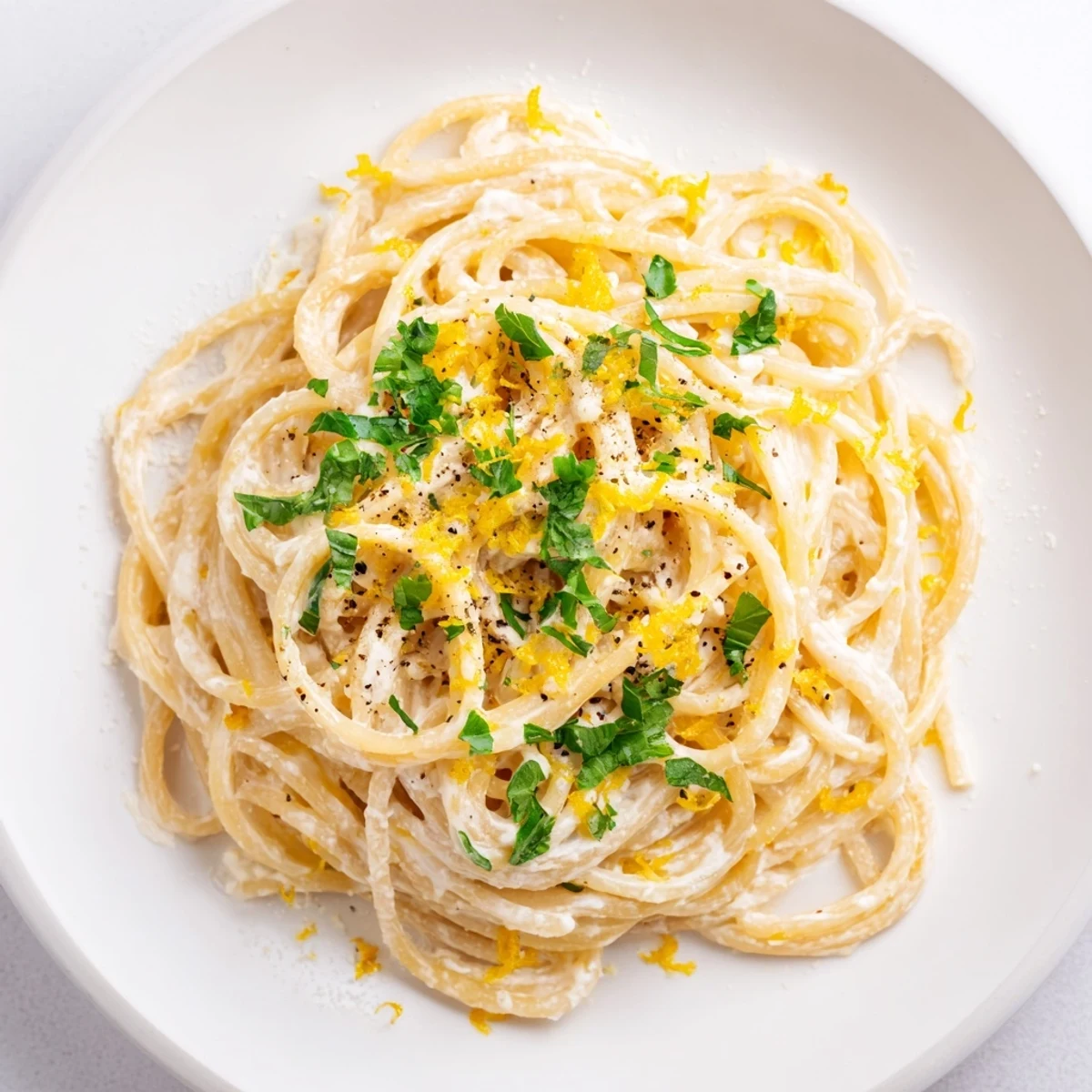 Creamy lemon ricotta pasta garnished with fresh basil, ready to eat in a wide bowl.