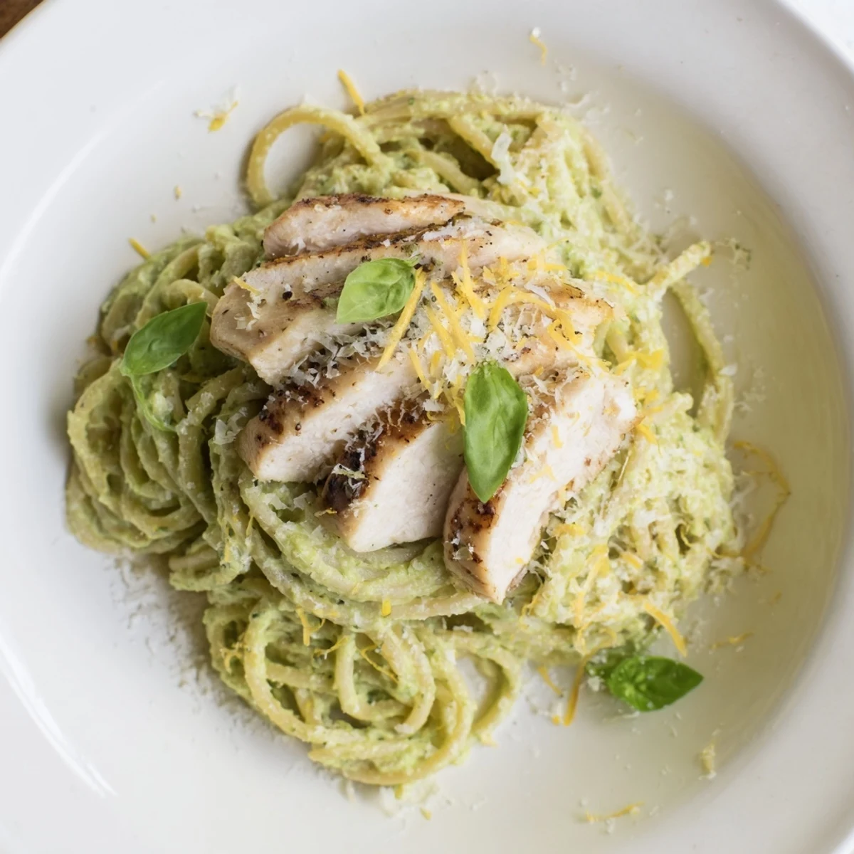 Creamy avocado chicken pasta, featuring grilled chicken and bright green avocado sauce, ready to serve.