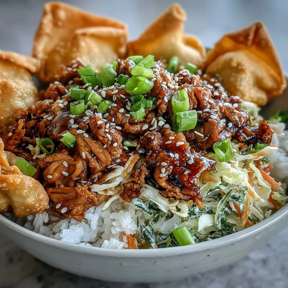 Crispy Baked Egg Roll Chicken Bowls served over fluffy rice, topped with golden baked wonton strips and fresh green onions.