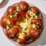 Warm pretzel bites arranged in a ring, filled with cheese, forming the tempting Pretzel Joy Wreath appetizer.