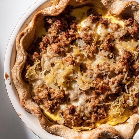 Golden-brown Bratwurst & Sauerkraut Pie with a crunchy pretzel crust, ready to serve with mustard.