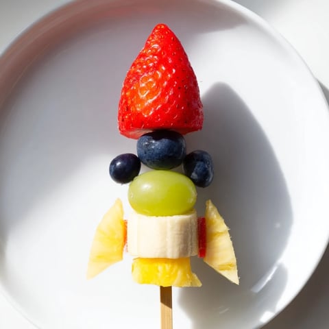 Rocket Ship Fruit Skewers: colorful, fresh fruit arranged into fun rocket shapes, ready for a kid's party.