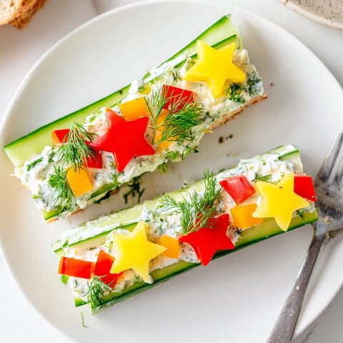 Holiday Star Cucumber Bites beautifully arranged on a platter with colorful bell pepper and dill garnishes.