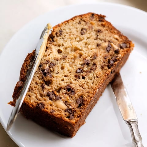 Pan de plátano avena mantequilla de maní y chips de chocolate recién horneado, corteza dorada y migas húmedas, perfecto para el desayuno.