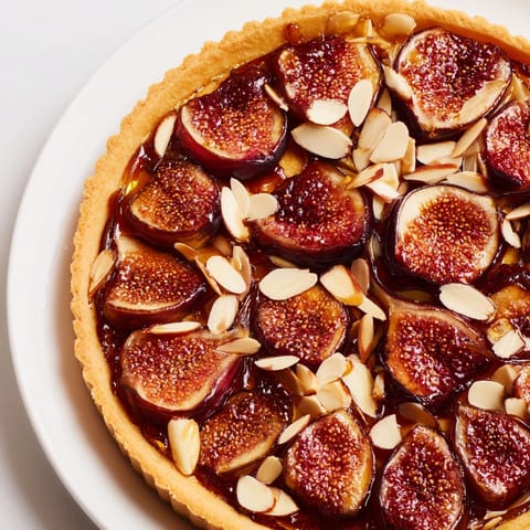 Deliciosos higos asados y almendras caramelizadas, perfecto sabor en cada bocado de tarta.