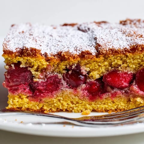 Moist almond cake infused with tangy cherries, creating vibrant Cherry Vibe Tarta de Santiago Bars.  