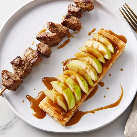 Tender lamb skewers infused with herbs, served alongside sweet caramel apple tartlets.  