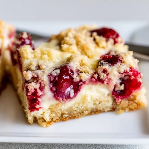 Deliciosos blondies de quesada con cerezas frescas, ideales para compartir en familia.  