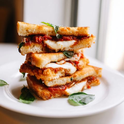 Golden Chicken Parm Grilled Cheese, featuring a gooey cheese pull on a warm, Italian-American sandwich.