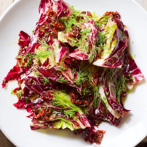 Freshly tossed Cabbage Salad With Sundried Tomatoes showcasing a medley of red and green cabbage, carrots, and herbs in a light, fragrant vinaigrette.
