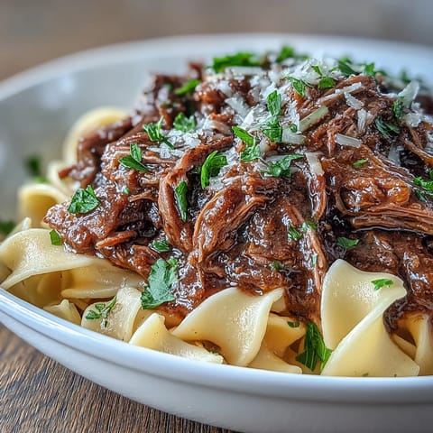 Slow-cooker Crockpot French Onion Pot Roast Pasta topped with melted Gruyère and fresh parsley.