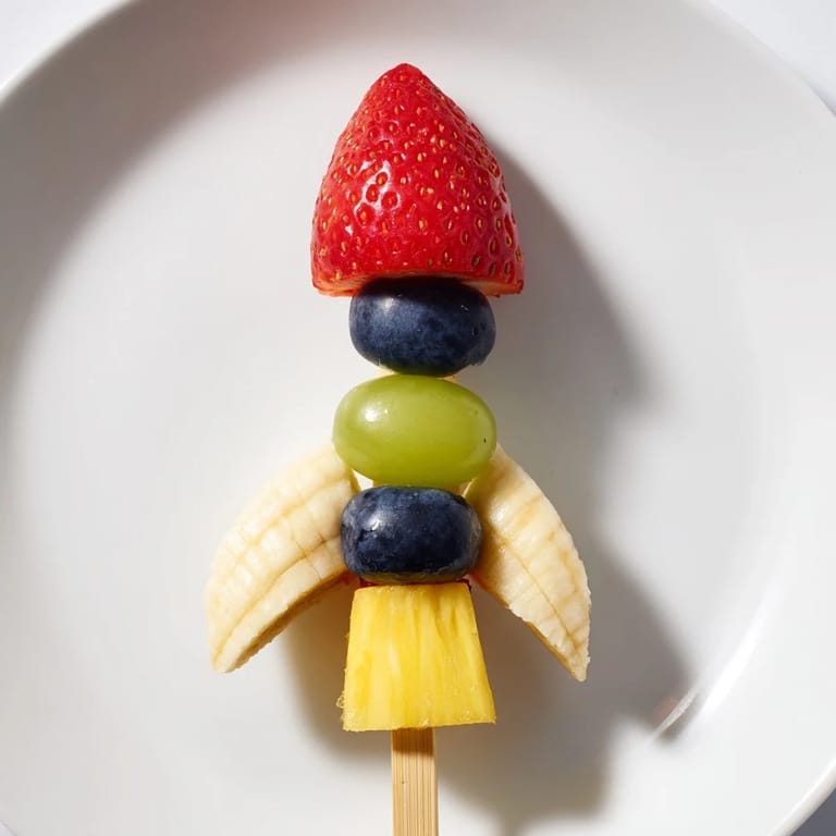 Vibrant Rocket Ship Fruit Skewers made with strawberries, pineapple, and grapes, a healthy snack idea.