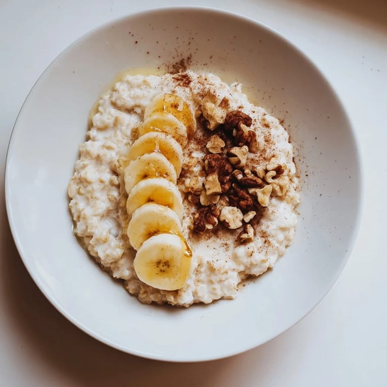 Close-up of a steaming bowl of microwave banana oats, with cinnamon and a drizzle of honey.
