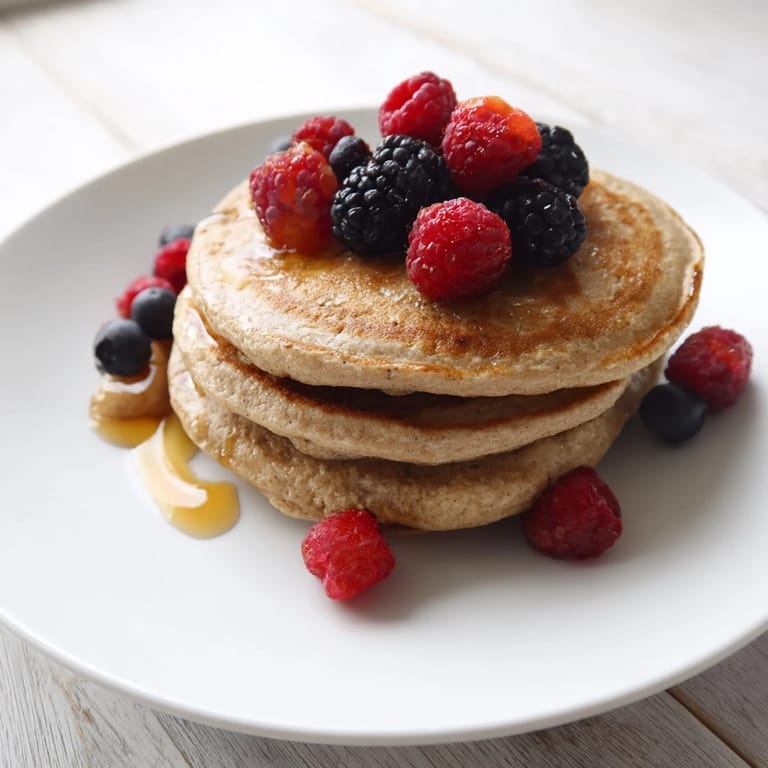 Close-up of golden brown banana pancakes, perfect for dipping in fresh maple syrup.