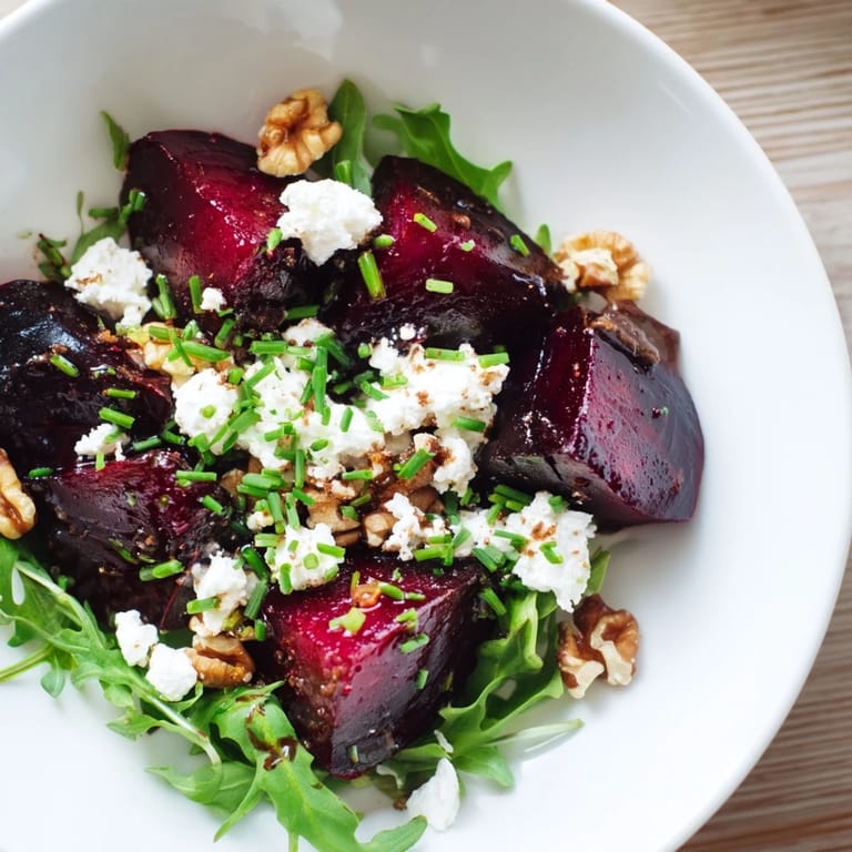 Vibrant Roasted Beet Goat Cheese Salad with crumbled goat cheese and toasted walnuts atop greens.