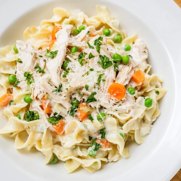 Close-up of a warm bowl of Spring Chicken Noodle Skillet garnished with fresh parsley.